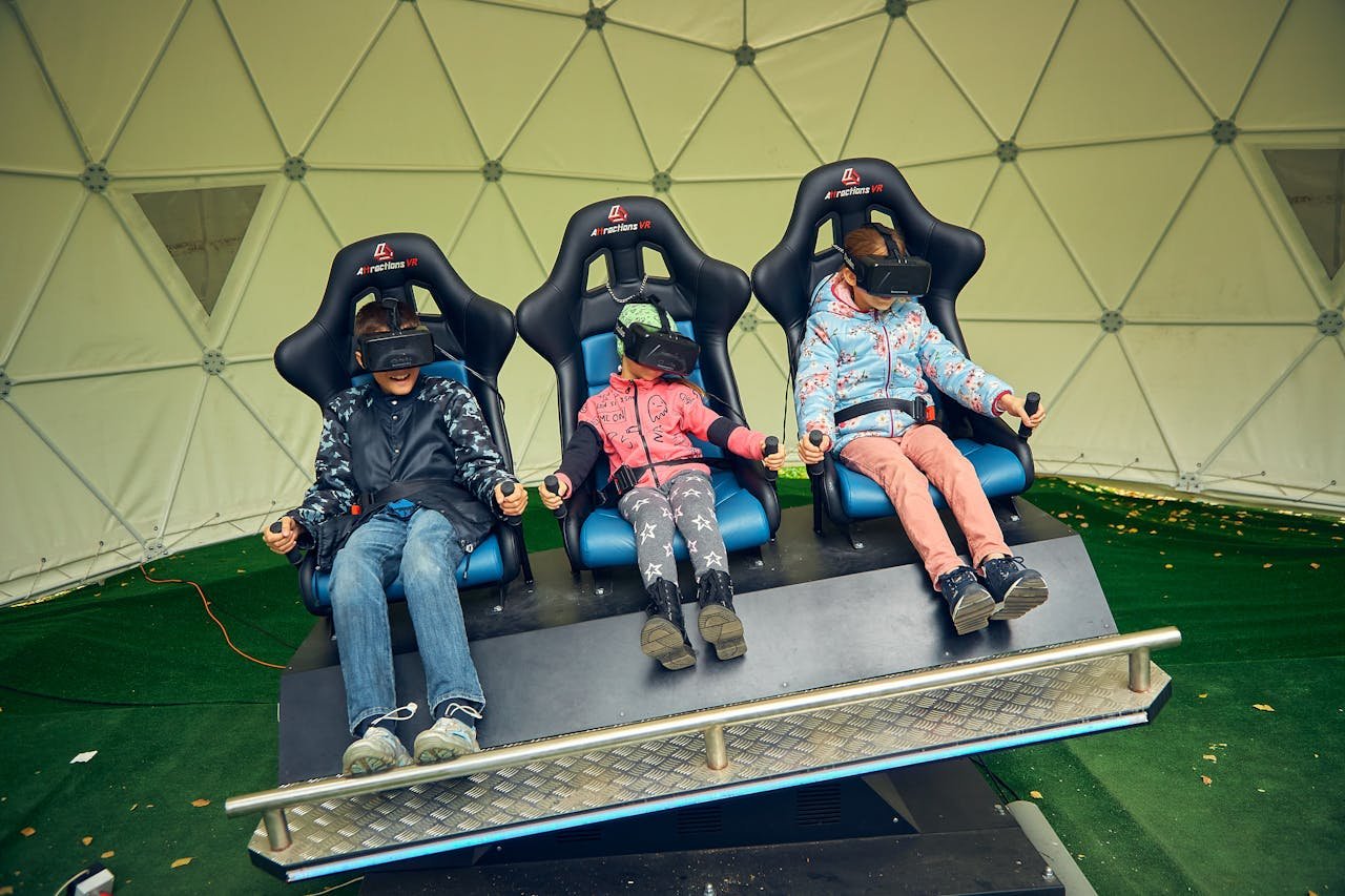 Three kids enjoy virtual reality in a VR simulator with headsets.