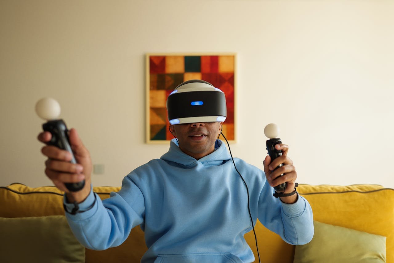 Adult man wearing VR headset and holding controllers, fully immersed in virtual reality gaming in a cozy living room.