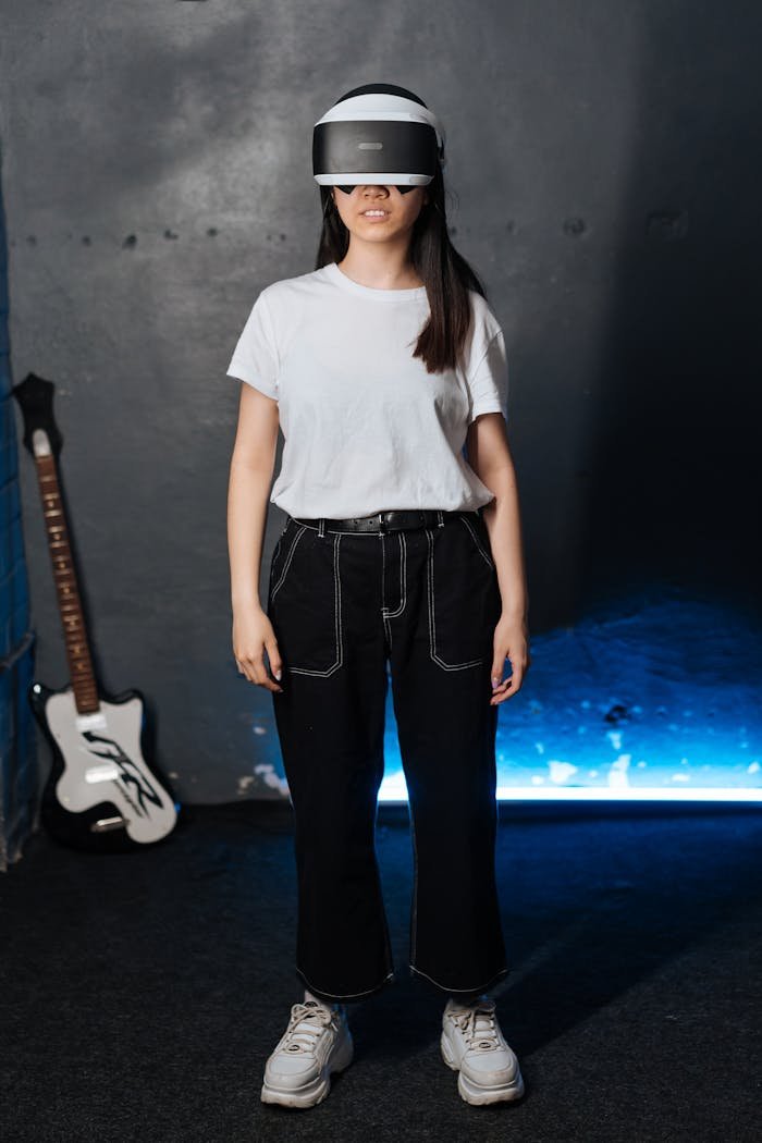 Young woman in VR headset standing near an electric guitar in a modern room.